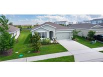 Charming single-story home showcasing a well-manicured lawn and attached two-car garage at 5043 Stokes Way, Wildwood, FL 34785