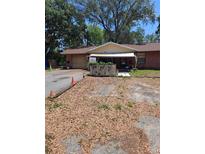 Cozy brick ranch-style home with awning and mature trees on a spacious lot at 5643 County Road 173, Wildwood, FL 34785