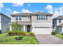 Charming two-story home with manicured lawn, brick driveway, and attached two car garage at 7627 Taormina Way, Clermont, FL 34714