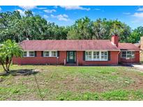 Charming brick home featuring a classic design and lush landscaping at 1007 N Shore Dr, Leesburg, FL 34748