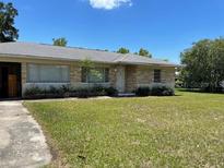 Charming single-story home featuring well-maintained lawn and neutral stone accents at 1022 E 3Rd Ave, Mount Dora, FL 32757