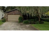 Charming exterior featuring a wood facade, stone accents, and an attached two-car garage at 111 Frosti Way, Eustis, FL 32726