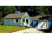 Charming blue home featuring a well-manicured front yard and a one-car garage at 1225 E 1St Ave, Mount Dora, FL 32757