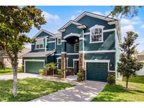 Elegant two-story home with a three-car garage, stone accents, and well-maintained landscaping at 12833 Hyland Ln, Clermont, FL 34711