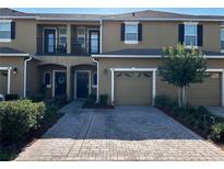 Inviting townhouse featuring a private balcony, one-car garage, and a charming brick paver driveway at 147 Aston Grande Dr, Daytona Beach, FL 32124