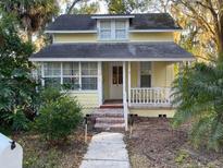 Charming two-story home with a covered front porch and lush landscaping, offering curb appeal at 148 W 9Th Ave, Mount Dora, FL 32757