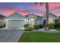 Charming single-story home featuring a lush, landscaped front yard and a convenient two-car garage at 1521 Southport St, The Villages, FL 32162