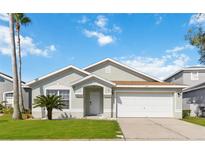 Charming single-story home featuring a well-manicured lawn, a two-car garage, and a welcoming front entrance at 157 Julliard Blvd, Davenport, FL 33897