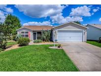 Charming single-story home with well-maintained lawn and a two-car garage at 17009 Se 96Th Chapelwood Cir, The Villages, FL 32162