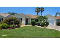 Charming single-story home features a well-manicured lawn, lush landscaping, and inviting curb appeal at 1701 Lakewood Dr, The Villages, FL 32162