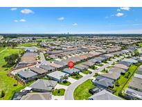Aerial view of a neighborhood with lush landscaping, lake and golf course at 2160 Biller Cir, The Villages, FL 32163