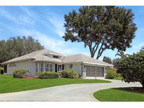 Charming single-story home featuring well-manicured landscaping and a spacious driveway, highlighting curb appeal at 21926 King Alfred St, Leesburg, FL 34748