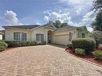Charming home featuring a brick driveway, manicured landscaping, and a welcoming entrance at 2415 Twickingham Ct, Clermont, FL 34711
