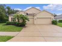 Charming home with a two-car garage, lush landscaping, and well-maintained lawn at 2424 Plumadore Dr, Grand Island, FL 32735