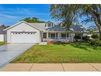 Charming single-Gathering home features a well-manicured lawn, two-car garage, and welcoming front porch at 508 Woodview Dr, Tavares, FL 32778
