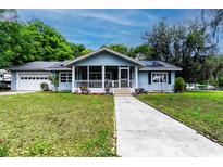 Charming single-story home with a welcoming screened front porch, well-manicured lawn, and a long concrete walkway at 513 Barwick St, Wildwood, FL 34785