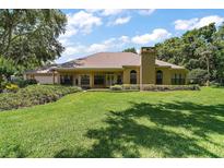 Charming single story home featuring a well-manicured lawn and beautiful landscaping at 621 High Point Dr, Mount Dora, FL 32757