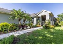 Charming home featuring a well-manicured lawn, lush landscaping, and a welcoming walkway at 7873 Crosswinds Way, Mount Dora, FL 32757