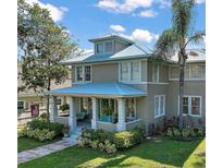 Charming two-story home featuring a welcoming front porch and beautifully landscaped front yard with a metal roof at 101 S Dixie Ave, Fruitland Park, FL 34731