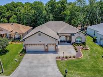 Beautiful single Gathering home with a three car garage, manicured lawn, and elegant landscaping at 10994 Se 168Th Loop, Summerfield, FL 34491