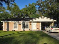 Charming single-story home featuring a well-maintained lawn and convenient carport at 1104 Flamingo Dr, Leesburg, FL 34748