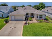 Charming single-story home with a well-manicured lawn and a two-car garage at 3112 Burbank Ln, The Villages, FL 32162