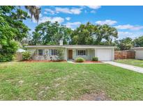 Charming single-story home with a well-manicured lawn and light blue shutters at 315 W 11Th Ave, Mount Dora, FL 32757