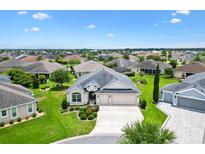 Beautiful single-story home featuring a lush lawn, landscaped beds, and a two-car garage in a well-maintained neighborhood at 3405 Nursery Pl, The Villages, FL 32163