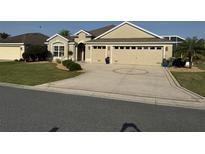Charming single-story home featuring a well-manicured lawn and a decorative driveway leading to a spacious two-car garage at 3411 Eisenhower Way, The Villages, FL 32163