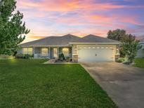 Beautiful home featuring a spacious garage, well-kept lawn, and lovely sunset views at 4730 Se 31St St, Ocala, FL 34480