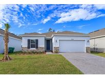Charming single-story home featuring a two-car garage, stone accents, and a well-manicured lawn at 5013 Balsam Falls Rd, Deland, FL 32724