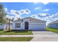 Charming single-story home featuring manicured lawn, neutral color palette, and brick-paved driveway and two-car garage at 5025 Balsam Falls Rd, Deland, FL 32724