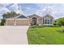 Charming single-story home with a three-car garage, manicured lawn, and a welcoming front entrance at 5944 Hickey Way, The Villages, FL 32163