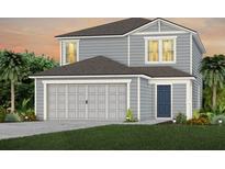 Two story home features a gray color scheme, a two car garage, and a well-manicured lawn at 7664 Agrigento St, Clermont, FL 34714