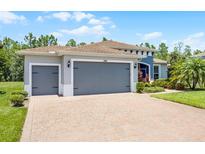Charming single-story home featuring a brick driveway and a three-car garage at 780 Mystic Hill Ct, Kissimmee, FL 34759