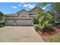 Charming single-story home featuring a paver driveway, three-car garage and manicured landscaping at 926 Wood Briar Loop, Sanford, FL 32771