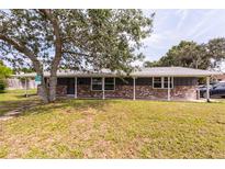 Charming single-story home featuring a brick facade, covered porch, and well-maintained front lawn at 110 River Beach Dr, Ormond Beach, FL 32176