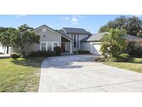 Charming home with a large driveway, gray siding, and well-maintained landscaping at 1226 Overlook Rd, Eustis, FL 32726