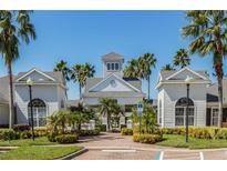 Elegant clubhouse featuring manicured landscaping, classic architecture, and beautiful palm trees at 130 Southern Pecan Cir # 204, Winter Garden, FL 34787