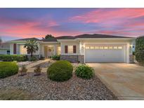 Charming single-story home features a well-manicured lawn, lovely landscaping, and a two-car garage at 13165 Se 93Rd Cir, Summerfield, FL 34491