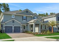 Charming two-story home featuring a brick driveway, two car garage, and beautifully landscaped front yard at 14261 Crest Palm Ave, Windermere, FL 34786