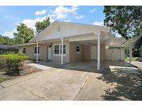 Charming single-story home featuring a covered carport and well-maintained landscaping at 1805 Jefferson Dr, Mount Dora, FL 32757