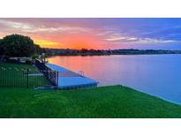 Scenic waterfront with a dock and beautiful sunset views, perfect for relaxing and enjoying the peaceful surroundings at 245 Blue Cypress Dr, Groveland, FL 34736