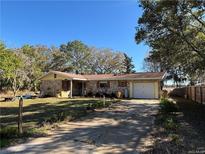 Charming single-story home featuring a stone facade, well-maintained lawn, and a private driveway at 24892 Sw Sailboat Dr, Dunnellon, FL 34431