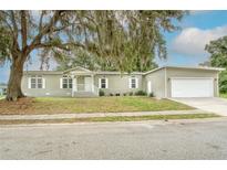 Charming single-story home featuring a well-manicured lawn and an attached two-car garage at 25156 Buttonwood Dr # 126, Astatula, FL 34705
