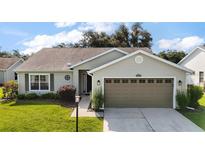 Charming single-story home with a well-maintained lawn, attached two-car garage and mature landscaping at 25406 Crestwater Dr, Leesburg, FL 34748