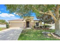 Charming single-story home with a well-manicured lawn, mature tree and inviting front entrance at 2889 Columbus Ave, Clermont, FL 34715
