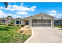 Charming single-story home features a screened garage, manicured lawn, and tasteful landscaping at 33417 Pennbrooke Pkwy, Leesburg, FL 34748