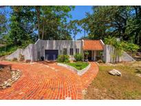 Charming home showcasing a beautiful red brick driveway, complemented by lush greenery and a blue garage door at 640 Sailfish Rd, Winter Springs, FL 32708