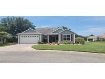 Well-maintained single-story home featuring a screened-in porch, two car garage and lovely landscaping at 8980 Se 176Th Limerick Ln, The Villages, FL 32162